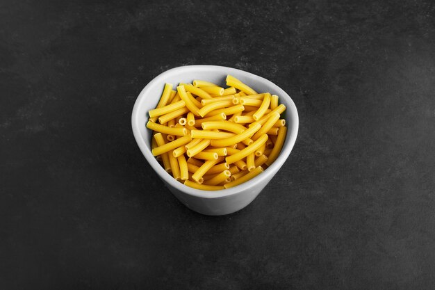 Pasta en un tazón blanco sobre negro.