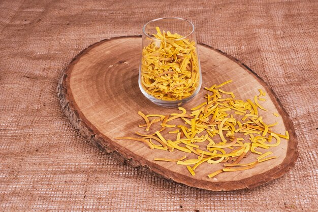 Pasta en un vaso sobre una tabla de madera.