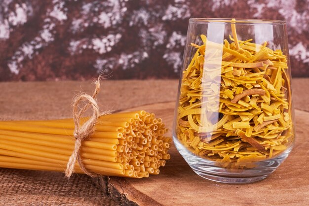 Pasta en un vaso sobre una tabla de madera.