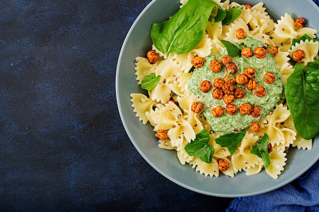 Pasta vegana Farfalle con salsa de espinacas y garbanzos fritos.