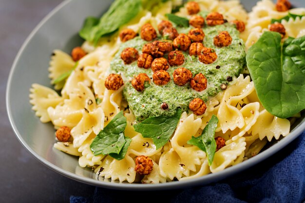 Pasta vegana Farfalle con salsa de espinacas y garbanzos fritos.