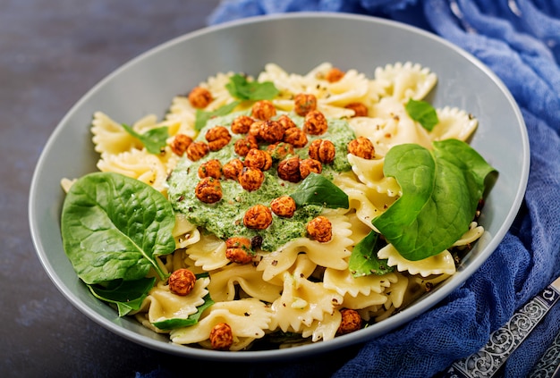 Pasta vegana Farfalle con salsa de espinacas y garbanzos fritos.