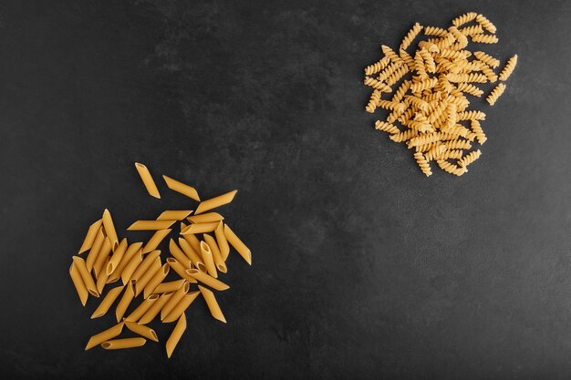 Pastas aisladas sobre fondo negro en esquinas opuestas.