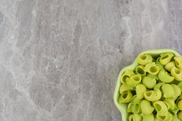 Pastas caseras verdes en platos en el espacio gris.