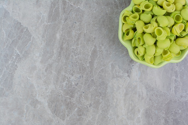 Pastas caseras verdes en una taza de cerámica sobre el mármol