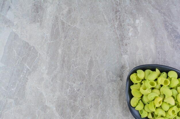 Pastas caseras verdes en una taza de cerámica sobre el mármol