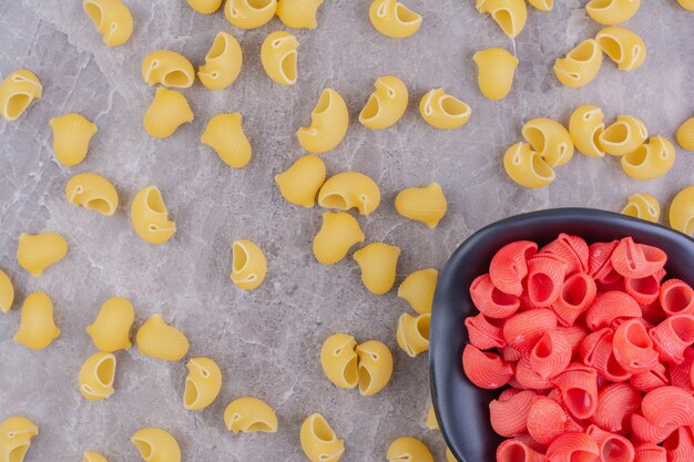 Pastas de color amarillo y rojo en la superficie de mármol