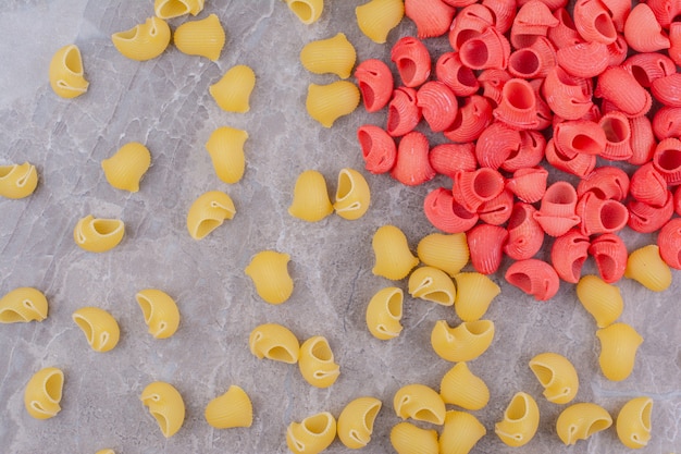 Pastas de color amarillo y rojo en la superficie de mármol