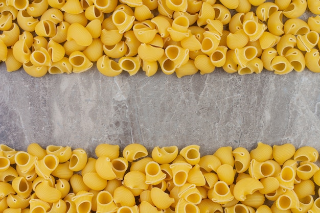 Pastas crudas aisladas en el espacio de mármol.