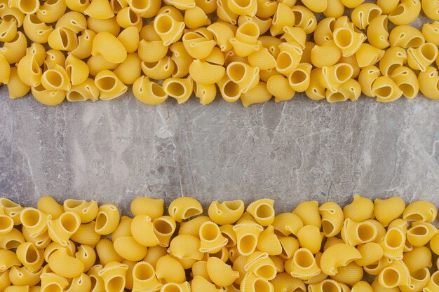 Pastas crudas aisladas en el espacio de mármol.