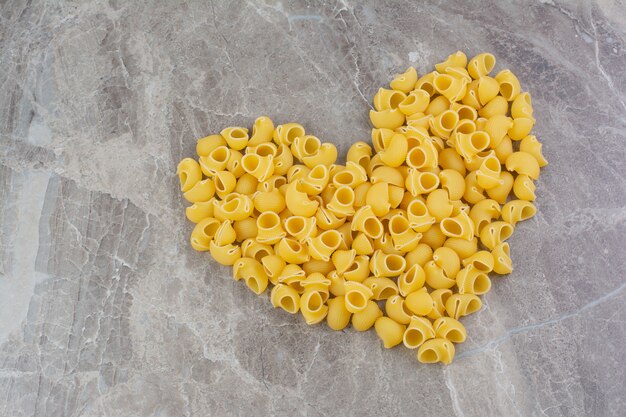 Pastas crudas aisladas en el espacio de mármol.