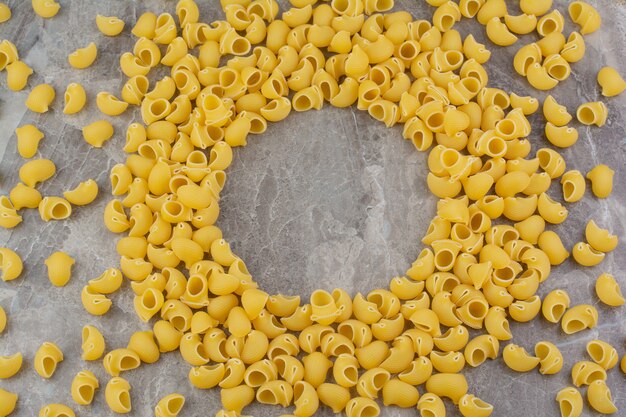 Pastas crudas aisladas en el espacio de mármol.