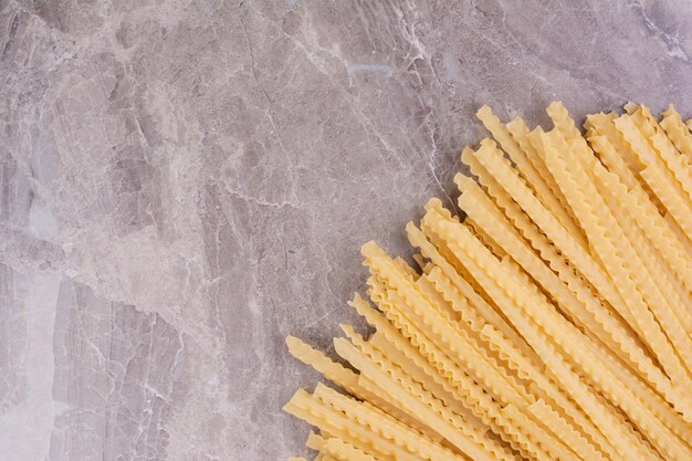 Pastas crudas y crudas aisladas en la superficie de mármol