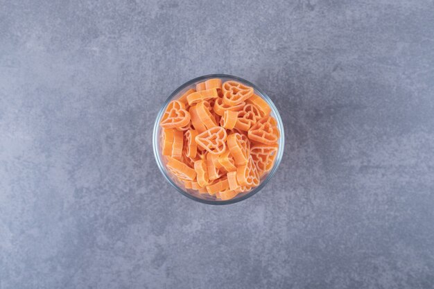 Pastas crudas en forma de corazón en un tazón de vidrio.