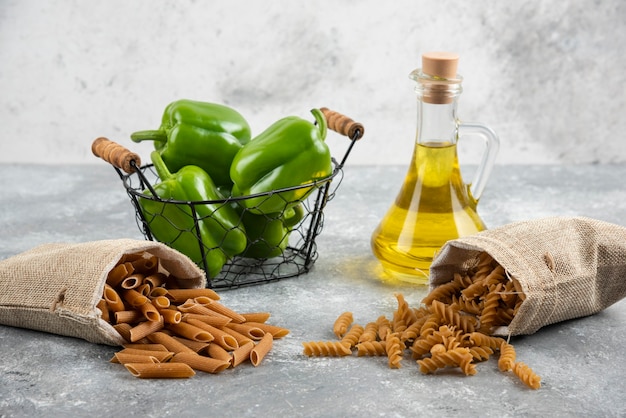 Pastas dietéticas en cestas con pimientos verdes y aceite de oliva.