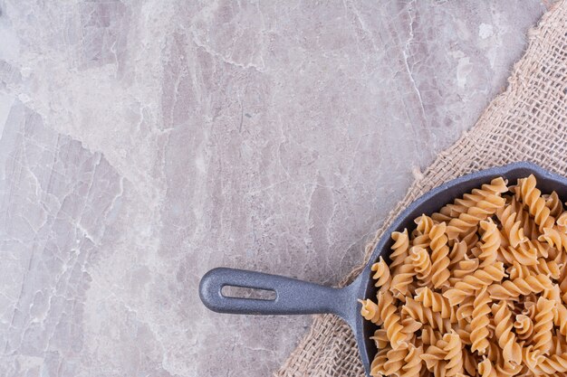 Pastas en forma de espiral en una sartén de hierro negro