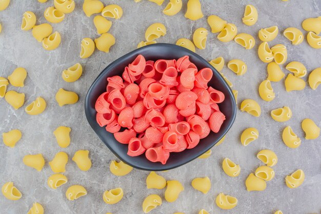 Pastas orgánicas amarillas y rojas sobre superficie gris