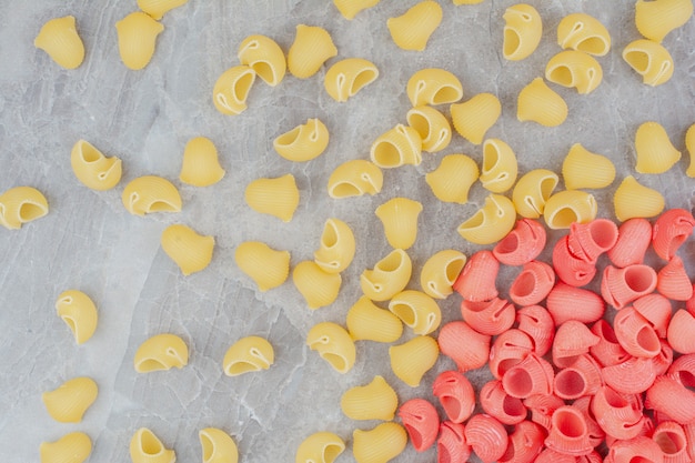 Pastas orgánicas amarillas y rojas sobre superficie gris