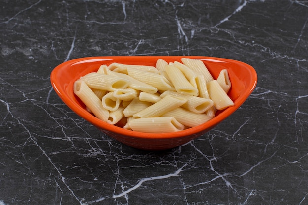 Pastas recién hervidas en un tazón de naranja.