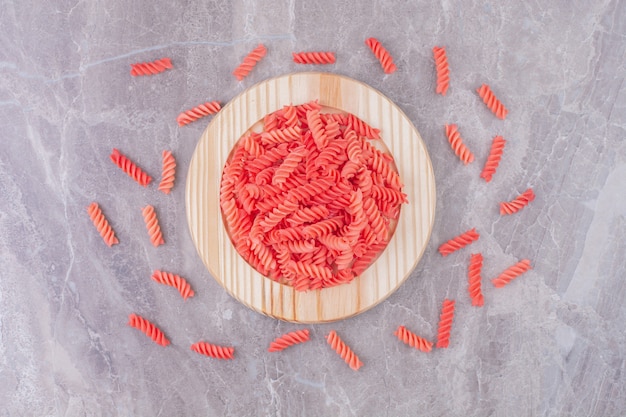 Pastas rojas en una placa de madera sobre el mármol