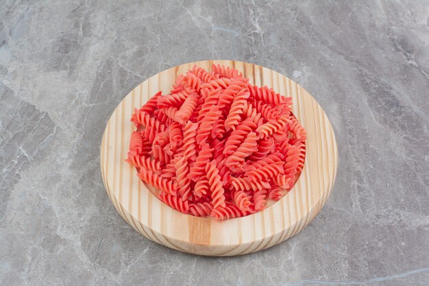 Pastas en salsa de tomate rojo en bandeja de madera