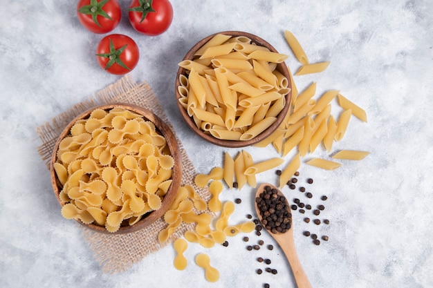 Pastas secas crudas colocadas sobre un fondo de mármol. Foto de alta calidad