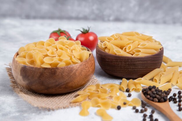 Pastas secas crudas colocadas sobre un fondo de mármol. Foto de alta calidad