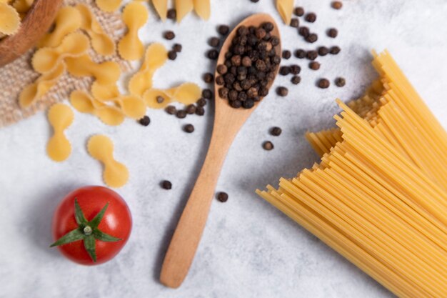 Pastas secas crudas colocadas sobre un fondo de mármol. Foto de alta calidad