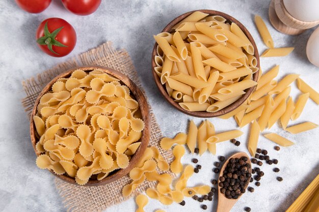 Pastas secas crudas colocadas sobre un fondo de mármol. Foto de alta calidad