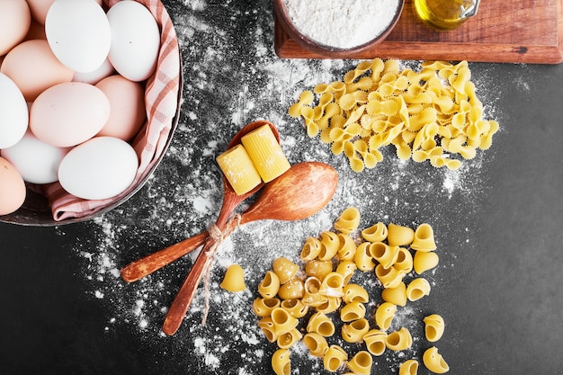 Pastas sobre la harina con huevos alrededor.