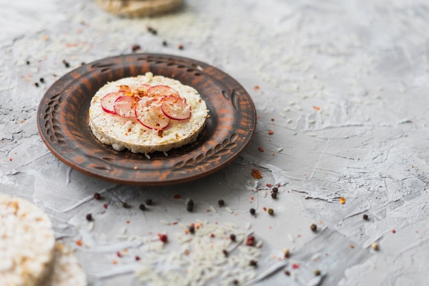 Foto gratuita pastel de arroz inflado redondo hecho en casa y decorado con rodajas de nabo y queso.