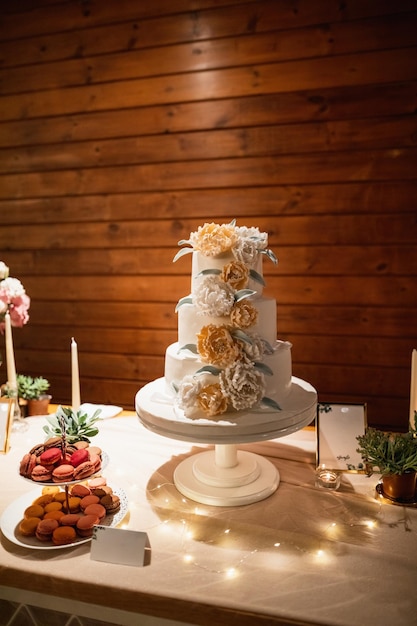 Pastel blanco con decoración floral en la recepción de la boda.