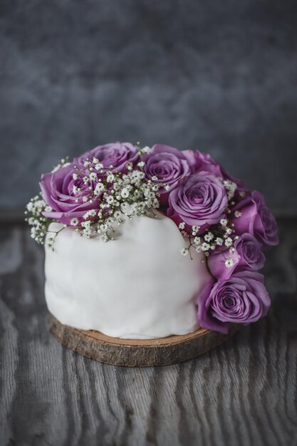 Pastel de boda rústico con rosas y deco en placa. De cerca