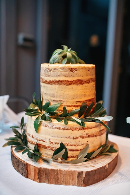 Foto gratuita pastel de bodas rústico desnudo decorado con hojas en un nivel de pastel de madera