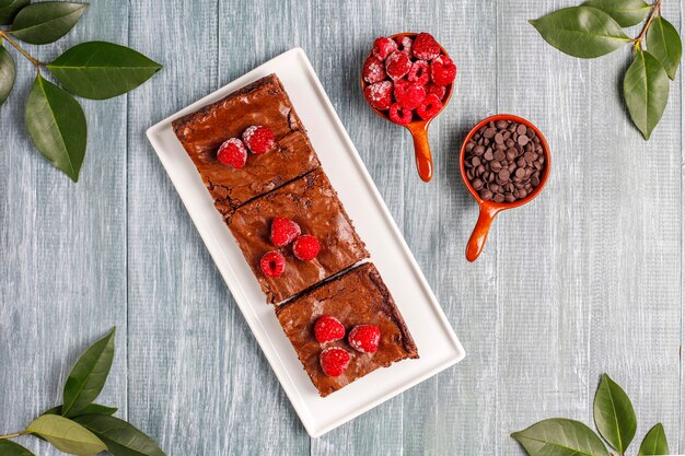 Pastel de brownie de chocolate rebanadas de postre con frambuesas y especias, vista superior