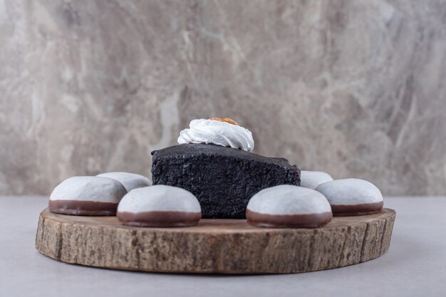 Pastel de brownies de chocolate amargo y mini mousse de hojaldre a bordo sobre el mármol.