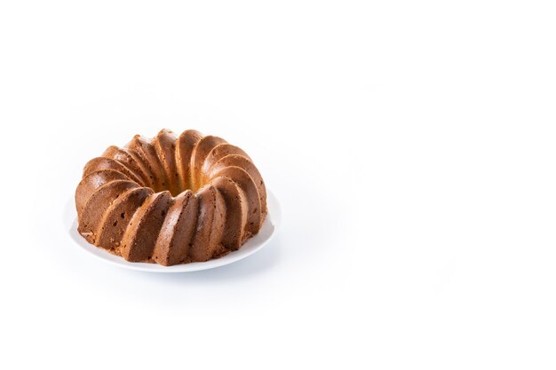 Pastel bundt tradicional con pasas aislado sobre fondo blanco.