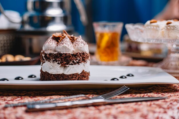 Pastel de cacao en capas con crema blanca y trozos de chocolate