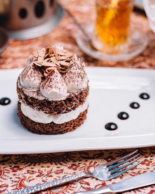 Pastel de cacao en capas con crema blanca y trozos de chocolate