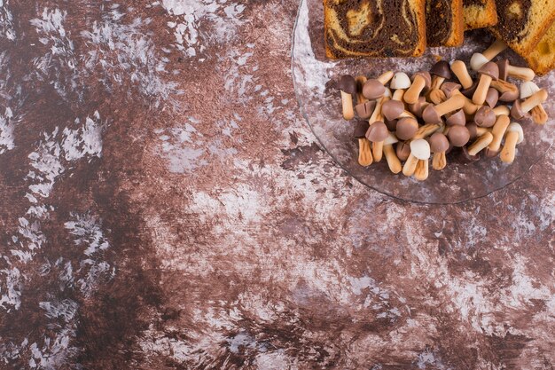 Pastel de cacao con gofres y galletas en bandeja de vidrio