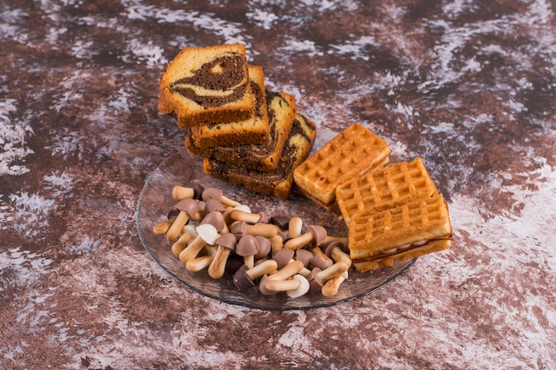 Foto gratuita pastel de cacao con gofres y galletas en bandeja de vidrio