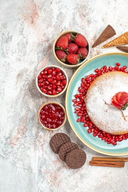 el pastel, canela, fresas, mermelada en un tazón, galletas de chocolate, y el pastel