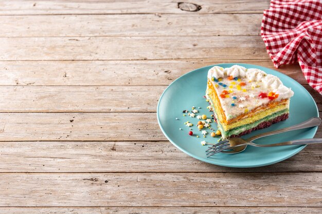 Pastel de capas de arco iris en la mesa de madera