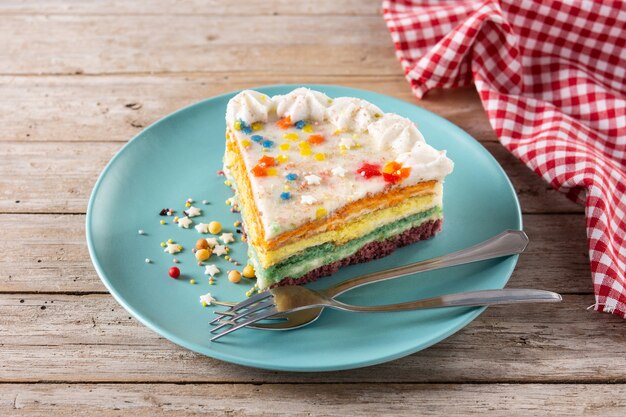 Pastel de capas de arco iris en la mesa de madera