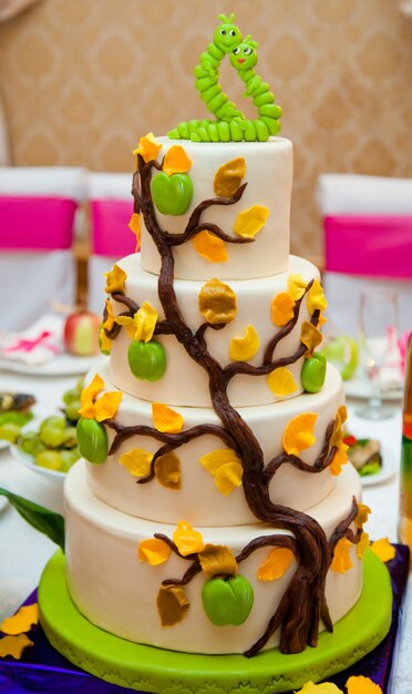 Pastel en capas decorado con dulces gusanos verdes en el amor