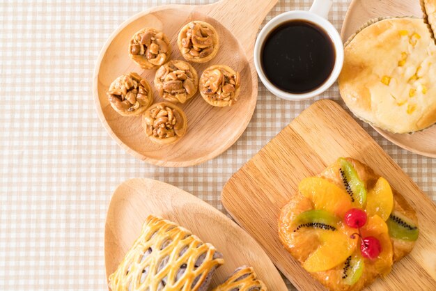 Pastel de caramelo, pan con mayonesa de maíz, tartas taro, fruta mixta danés con mermelada y taza de café