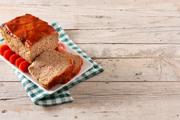 Pastel de carne americano tradicional con salsa de tomate en la mesa de madera rústica