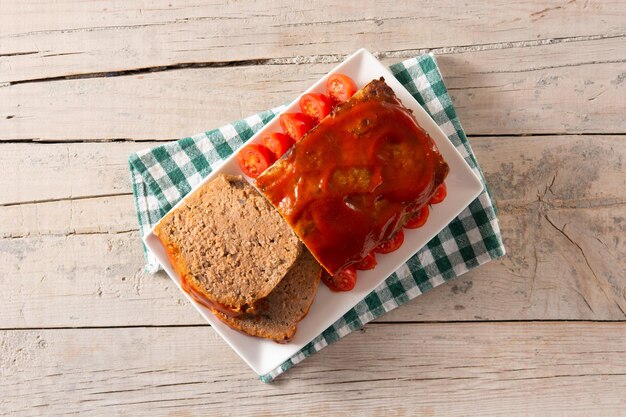 Pastel de carne americano tradicional con salsa de tomate en la mesa de madera rústica