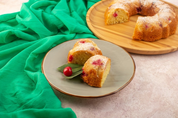 Un pastel de cereza vista frontal rebanadas deliciosas y deliciosas en el escritorio rosa