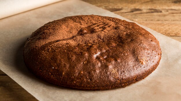 Pastel de chocolate de alto ángulo con cacao en polvo